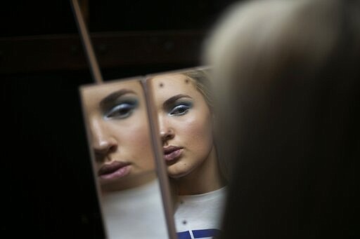 Emily Tressa, 18, examines her makeup ahead of a fashion show with transfeminine, transmasculine and non-binary models on Friday, Jan. 31, 2020, in Boston. Emily has lived as a girl since fourth grade. With gender reassignment surgery last June, her transformation became complete. (AP Photo/Wong Maye-E)