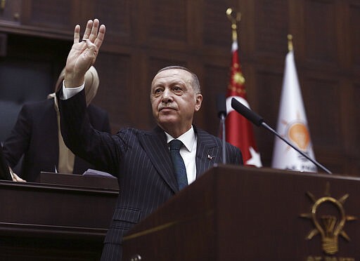 Turkish President Recep Tayyip Erdogan gestures as he addresses the members of his ruling party in Parliament, in Ankara, Turkey, Wednesday, March 4, 2020. Erdogan called on Greece and other European nations to respect migrants rights.(AP Photo/Burhan Ozbilici)