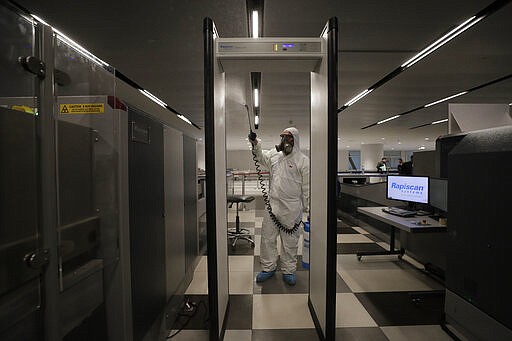 A worker wearing protective gear sprays disinfectant as a precaution against the coronavirus outbreak, in the departure terminal at the Rafik Hariri International Airport, in Beirut, Lebanon, Thursday, March 5, 2020. The novel coronavirus has infected more than 80,000 people globally, causing around 2,700 deaths, mainly in China. (AP Photo/Hassan Ammar)