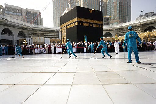 Workers sterilize the ground in front of the Kaaba, the cubic building at the Grand Mosque, in the Muslim holy city of Mecca, Saudi Arabia, Thursday, March 5, 2020. Saudi Arabia's Deputy Health Minister Abdel-Fattah Mashat was quoted on the state-linked news site Al-Yaum saying that groups of visitors to Mecca from inside the country would now also be barred from performing the pilgrimage, known as the umrah. (AP Photo/Amr Nabil)