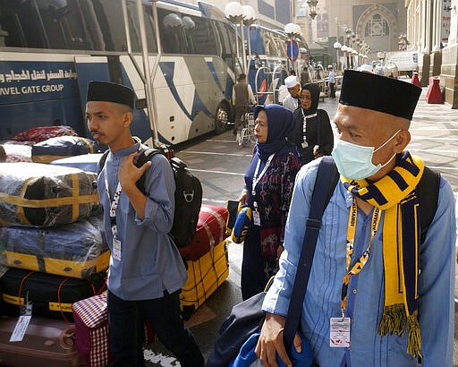 Indonesian pilgrims, who entered Mecca before halting the visas, wait their bus to leave home in the Muslim holy city of Mecca, Saudi Arabia, Thursday, March 5, 2020. Saudi Arabia's Deputy Health Minister Abdel-Fattah Mashat was quoted on the state-linked news site Al-Yaum saying that groups of visitors to Mecca from inside the country would now also be barred from performing the pilgrimage, known as the umrah. (AP Photo/Amr Nabil)