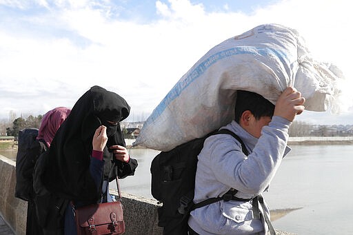 Migrants walk on a bridge in Edirne near the Turkish-Greek border on Thursday, March 5, 2020. Turkey has vowed to seek justice for a migrant it says was killed on the border with Greece after Greek authorities fired tear gas and stun grenades to push back dozens of people attempting to cross over. Greece had denied that anyone was killed in the clashes. (AP Photo/Darko Bandic)