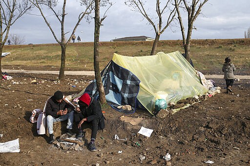 Migrants sit by an improvised tent in Edirne near the Turkish-Greek border on Thursday, March 5, 2020. Greece countered accusations from Turkey Wednesday that it was responsible for the death of a migrant, as its border authorities strove for a sixth day to keep thousands of migrants out by using tear gas, stun grenades and water cannons.AP Photo/Emrah Gurel)