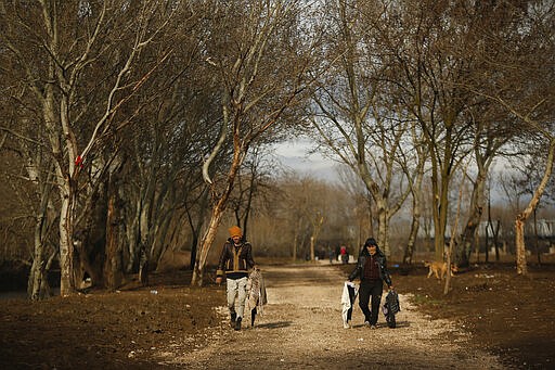 Migrants carry laundry in Edirne near the Turkish-Greek border on Thursday, March 5, 2020. Greece countered accusations from Turkey Wednesday that it was responsible for the death of a migrant, as its border authorities strove for a sixth day to keep thousands of migrants out by using tear gas, stun grenades and water cannons. (AP Photo/Emrah Gurel)