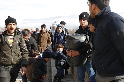 Migrants walk on a bridge in Edirne near the Turkish-Greek border on Thursday, March 5, 2020. Turkey has vowed to seek justice for a migrant it says was killed on the border with Greece after Greek authorities fired tear gas and stun grenades to push back dozens of people attempting to cross over. Greece had denied that anyone was killed in the clashes. (AP Photo/Darko Bandic)