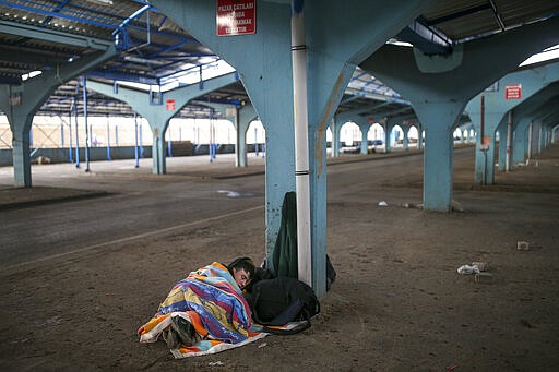 A migrant sleeps at a city market area in Edirne near the Turkish-Greek border on Thursday, March 5, 2020. Greece countered accusations from Turkey Wednesday that it was responsible for the death of a migrant, as its border authorities strove for a sixth day to keep thousands of migrants out by using tear gas, stun grenades and water cannons.AP Photo/Emrah Gurel)