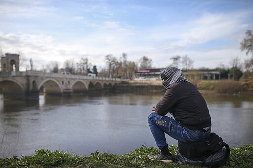 A migrant sits on his belongings in Edirne near the Turkish-Greek border on Thursday, March 5, 2020. Greece countered accusations from Turkey Wednesday that it was responsible for the death of a migrant, as its border authorities strove for a sixth day to keep thousands of migrants out by using tear gas, stun grenades and water cannons.AP Photo/Emrah Gurel)