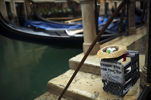 Gondolas are parked on a rainy day in Venice, Sunday, March 1, 2020. Venice in the time of coronavirus is a shell of itself, with empty piazzas, shuttered basilicas and gondoliers idling their days away. The cholera epidemic that raged quietly through Venice in Thomas Mann's fictional &quot;Death in Venice&quot; has been replaced by a real life fear of COVID-19. (AP Photo/Francisco Seco)