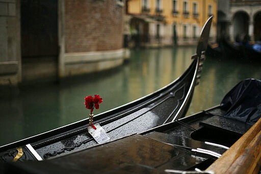 Gondolas are parked on a rainy day in Venice, Sunday, March 1, 2020. Venice in the time of coronavirus is a shell of itself, with empty piazzas, shuttered basilicas and gondoliers idling their days away. The cholera epidemic that raged quietly through Venice in Thomas Mann's fictional &quot;Death in Venice&quot; has been replaced by a real life fear of COVID-19. (AP Photo/Francisco Seco)