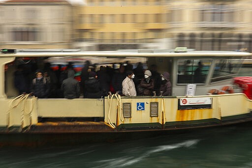 Commuters and locals take a bus boat in Venice, Italy, Monday, March 2, 2020. Venice in the time of coronavirus is a shell of itself, with empty piazzas, shuttered basilicas and gondoliers idling their days away. The cholera epidemic that raged quietly through Venice in Thomas Mann's fictional &quot;Death in Venice&quot; has been replaced by a real life fear of COVID-19. (AP Photo/Francisco Seco)