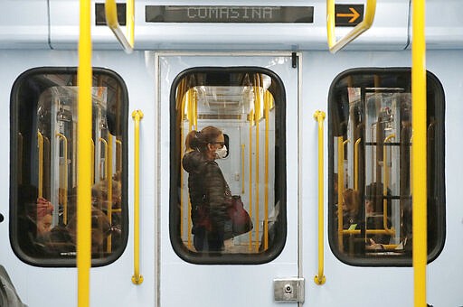 A woman wearing a face mask stands in a subway train in Milan, Italy, Thursday, March 5, 2020. Italy's virus outbreak has been concentrated in the northern region of Lombardy, but fears over how the virus is spreading inside and outside the country has prompted the government to close all schools and Universities nationwide for two weeks. (AP Photo/Antonio Calanni)