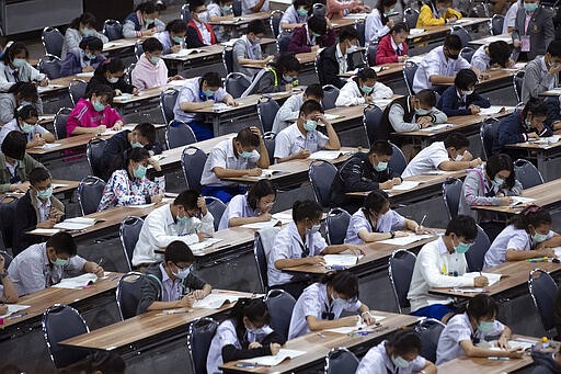 Middle school students wear protective masks as they take an entrance examination for high school in Bangkok, Thailand, Thursday, March 5, 2020. Thailand reported its first death form COVID -19 illness on Sunday. (AP Photo/Sakchai Lalit)