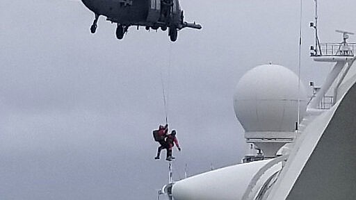 CORRECTS FROM COAST GUARD TO NATIONAL GUARD HELICOPTER- In this photo provided by Michele Smith, a National Guard  helicopter delivering virus testing kits lowers crew down to the Grand Princess cruise ship Thursday, March 5, 2020, off the California coast. Scrambling to keep the coronavirus at bay, officials ordered a cruise ship with about 3,500 people aboard to hold off the California coast Thursday until passengers and crew could be tested, after a traveler from its previous voyage died and at least one other became infected. Princess Cruises says fewer than 100 of those aboard have been identified for testing. (Michele Smith via AP)