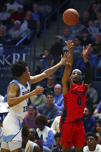 Dayton's Rodney Chatman (0) shoots a three-pointer over Rhode Island's Jeff Dowtin (11) during the first half of an NCAA college basketball game Wednesday, March 4, 2020, in Kingston, R.I. (AP Photo/Stew Milne)