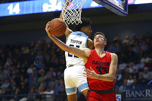 Dayton's Ryan Mikesell (33) takes a shot past the defense of Rhode Island's Jacob Toppin (21) during the first half of an NCAA college basketball game Wednesday, March 4, 2020, in Kingston, R.I. (AP Photo/Stew Milne)