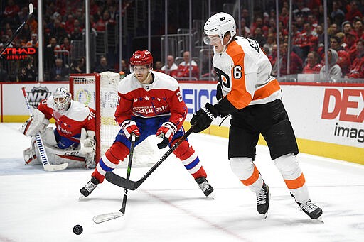 Philadelphia Flyers defenseman Travis Sanheim (6) and Washington Capitals center Lars Eller (20) chase the puck during the first period of an NHL hockey game Wednesday, March 4, 2020, in Washington. (AP Photo/Nick Wass)