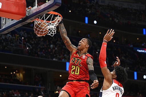 Atlanta Hawks forward John Collins (20) dunks past Washington Wizards forward Rui Hachimura (8), of Japan, during the first half of an NBA basketball game, Friday, March 6, 2020, in Washington. (AP Photo/Nick Wass)