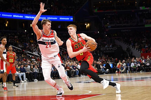 Atlanta Hawks guard Kevin Huerter, right, drives to the basket next to Washington Wizards forward Moritz Wagner (21) during the first half of an NBA basketball game, Friday, March 6, 2020, in Washington. (AP Photo/Nick Wass)