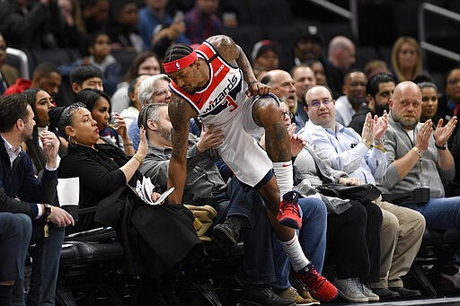 Washington Wizards guard Bradley Beal (3) falls into the first row during the first half of an NBA basketball game against the Atlanta Hawks, Friday, March 6, 2020, in Washington. (AP Photo/Nick Wass)