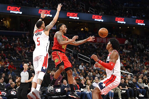 Atlanta Hawks guard Jeff Teague (00) passes th eballl between Washington Wizards guard Shabazz Napier (5) and forward Rui Hachimura, right, during the first half of an NBA basketball game, Friday, March 6, 2020, in Washington. (AP Photo/Nick Wass)