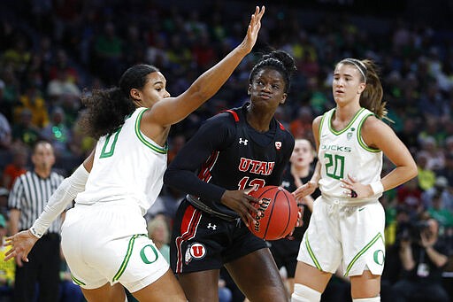 Utah's Lola Pendande (12) drives into Oregon's Satou Sabally (0) during the first half of an NCAA college basketball game in the quarterfinal round of the Pac-12 women's tournament Friday, March 6, 2020, in Las Vegas. (AP Photo/John Locher)