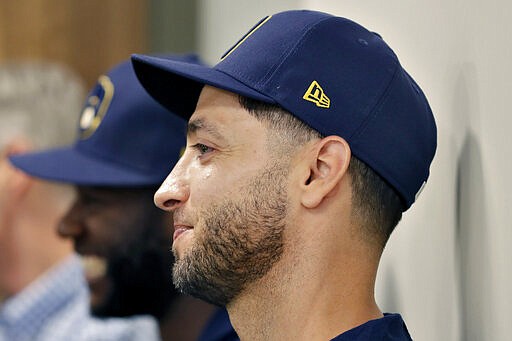 Milwaukee Brewers' Ryan Braun listens as the Brewers announce teammate Christian Yelich's multi-year contract extension at the teams' spring training facility Friday, March 6, 2020, in Phoenix. (AP Photo/Matt York)