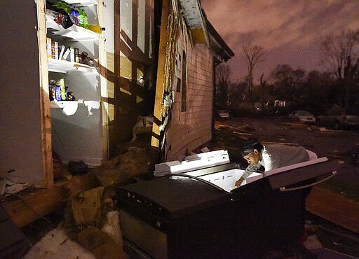 In this Tuesday, March 3, 2020 photo, Nicole (last name not given) looks through her refrigerator after it was ripped out of her home at Underwood St. and 16th Ave. N. after a tornado ripped a wall off in the Elizabeth Park neighborhood of Nashville, Tenn. (George Walker IV/The Tennessean via AP)