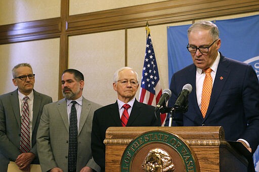 REMOVES REFERENCE TO NUMBER OF PEOPLE WHO DIED FROM COVID-19 - From right to left, Gov. Jay Inslee, Insurance Commissioner Mike Kreidler, Director of the Department of Labor &amp; Industries Joel Sacks, and Health Secretary John Wiesman meet with the media to discuss the latest update on coronavirus in the state, Thursday, March 5, 2020, in Olympia, Wash. Inslee announced that the state will cover the costs of tests for those who are uninsured, but whose doctors believe they need testing.  (AP Photo/Rachel La Corte)