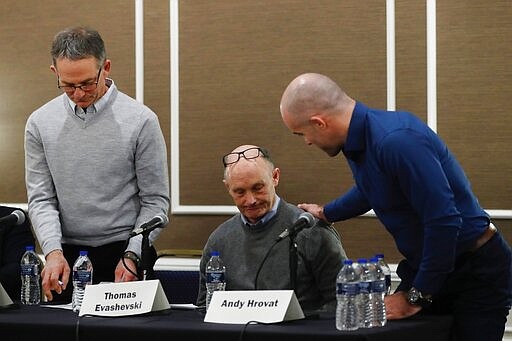 Andy Hrovat, right, talks with Thomas Evashevski after a news conference, Thursday, Feb. 27, 2020 in Southfield, Mich. Hrovat, Evashevski and Tad Deluca, left, are three of the University of Michigan wrestlers who say they were abused by a sports doctor. (AP Photo/Carlos Osorio)