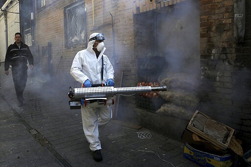 A firefighter disinfects a traditional shopping center to help prevent the spread of the new coronavirus in northern Tehran, Iran, Friday, March, 6, 2020.  A Health Ministry spokesman warned authorities could use unspecified &#147;force&#148; to halt travel between major cities. (AP Photo/Ebrahim Noroozi)