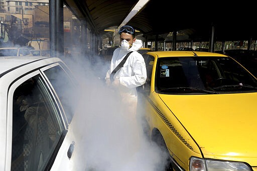 A firefighter disinfects a taxi stand to help prevent the spread of the new coronavirus in northern Tehran, Iran, Friday, March, 6, 2020.  A Health Ministry spokesman warned authorities could use unspecified &#147;force&#148; to halt travel between major cities.(AP Photo/Ebrahim Noroozi)