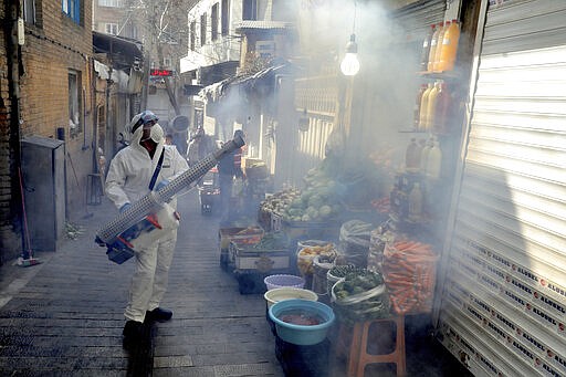 A firefighter disinfects a traditional shopping center to help prevent the spread of the new coronavirus in northern Tehran, Iran, Friday, March, 6, 2020. A Health Ministry spokesman warned authorities could use unspecified &#147;force&#148; to halt travel between major cities. (AP Photo/Ebrahim Noroozi)