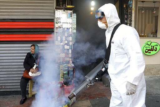 A firefighter disinfects a traditional shopping center to help prevent the spread of the new coronavirus in northern Tehran, Iran, Friday, March, 6, 2020.  A Health Ministry spokesman warned authorities could use unspecified &#147;force&#148; to halt travel between major cities.  (AP Photo/Ebrahim Noroozi)