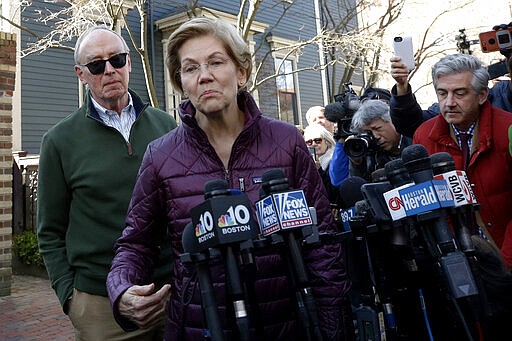 Sen. Elizabeth Warren, D-Mass., with her husband Bruce Mann beside her, speaks to the media outside her home, Thursday, March 5, 2020, in Cambridge, Mass., after she dropped out of the Democratic presidential race. (AP Photo/Steven Senne)