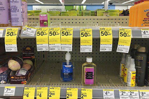 FILE - In this Feb. 28, 2020 file photo, only a few bottles of hand sanitizers remain on the shelves at a Walgreen Pharmacy in Miami Shores, Fla.   Legions of nervous hoarders are stocking up on canned goods, frozen dinners, toilet paper, and cleaning products.  Such hoarding that's expected to last for weeks has created big challenges for discounters and grocery stores as well as food delivery services. (AP Photo/Marta Lavandier, File)