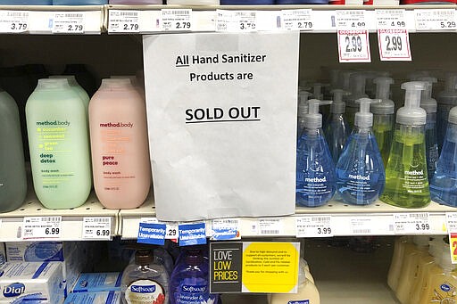 FILE - In this March 3, 2020 file photo, a sign on a shelf at a QFC grocery store in Kirkland, Wash., advises shoppers that all hand sanitizer products are sold out.    Legions of nervous hoarders are stocking up on canned goods, frozen dinners, toilet paper, and cleaning products.  Such hoarding that's expected to last for weeks has created big challenges for discounters and grocery stores as well as food delivery services. (AP Photo/Ted S. Warren, File)