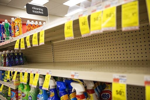 FILE - In this March 4, 2020 file photo, shelves where disinfectant wipes and sprays are usually displayed sit empty in a pharmacy in Providence, R.I., as confirmed cases of the coronavirus rise in the U.S.   Legions of nervous hoarders are stocking up on canned goods, frozen dinners, toilet paper, and cleaning products.  Such hoarding that's expected to last for weeks has created big challenges for discounters and grocery stores as well as food delivery services.  (AP Photo/David Goldman, File)