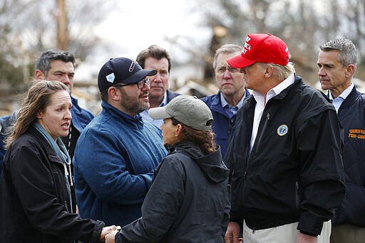 President Donald Trump, accompanied by Tennessee First Lady Maria Lee, center, speaks with residents Matt and Angela Suggs as they tour damage from a recent tornado, Friday, March 6, 2020, in Cookeville, Tenn. (AP Photo/Alex Brandon)