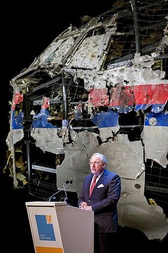 -FILE- In this Tuesday, Oct. 13, 2015, file image, with the reconstructed cockpit displayed behind, Tjibbe Joustra, head of the Dutch Safety Board presents the board's final report into what caused Malaysia Airlines Flight 17 to break up high over Eastern Ukraine last year, killing all 298 people on board, during a press conference in Gilze-Rijen, central Netherlands. United by grief across oceans and continents, families who lost loved ones when Malaysia Airlines Flight 17 was shot down in 2014 hope that a trial starting next week will finally deliver them something that has remained elusive ever since: The truth. (AP Photo/Peter Dejong, File)