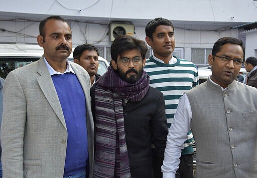 FILE - In this Wednesday, Jan. 29, 2020 file photo, plain clothes policemen escort Indian student Sharjeel Imam, center, as he is brought to be produced before a court in New Delhi, India. Critics, intellectuals, human rights activists, filmmakers, students and journalists in seen as opposed to Indian Prime Minister Narendra Modi's&#160;government are being increasingly silenced under a colonial-era sedition law. Official data reveal as many as 332 people were arrested under the law between 2016 and 2018, though only seven were convicted, suggesting that the police&#160;have struggled to gather evidence against the accused. (AP Photo/Dinesh Joshi)