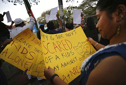 In this Tuesday, Feb. 4, 2020 photo, an Indian woman reads a placard before participating in a protest against the sedition case filed by police against a school after a play preformed by students denouncing a new citizenship law, in Bangalore, India. Critics, intellectuals, human rights activists, filmmakers, students and journalists in seen as opposed to Indian Prime Minister Narendra Modi's&#160;government are being increasingly silenced under a colonial-era sedition law. Official data reveal as many as 332 people were arrested under the law between 2016 and 2018, though only seven were convicted, suggesting that the police&#160;have struggled to gather evidence against the accused. (AP Photo/Aijaz Rahi)