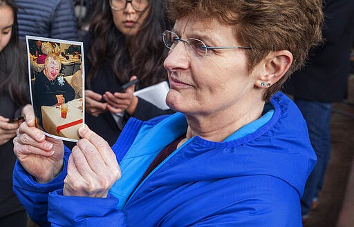 Pat Herrick holds a photo of her mother, Elaine, a resident of Life Care Center who died earlier in the day, Thursday, March 5, 2020, in Kirkland, Wash. Family members of residents of the nursing home where multiple people have died from the coronavirus spoke to the media about their loved ones as Washington state authorities reported dozens more cases. (Steve Ringman/The Seattle Times via AP)