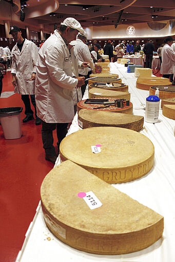 Judge Christophe Megevand inspects a wheel of Gruyere cheese at the biennial World Championship Cheese Contest, Tuesday, March 3, 2020, at the Monona Terrace Convention Center in Madison, Wis. It's the largest technical cheese, butter and yogurt competition in the world. This year the competition had a record 3,667 entries from 26 nations. (AP Photo/Carrie Antlfinger)