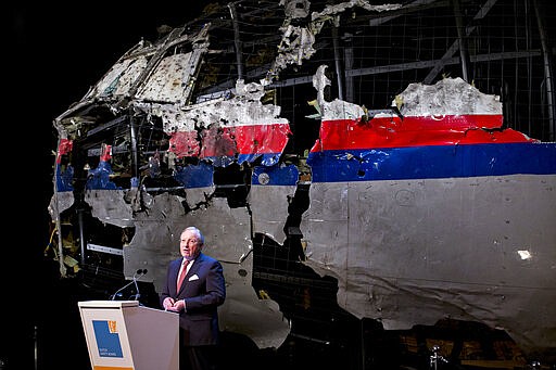 -FILE- In this Tuesday, Oct. 13, 2015, file image, with the reconstructed cockpit displayed behind, Tjibbe Joustra, head of the Dutch Safety Board presents the board's final report into what caused Malaysia Airlines Flight 17 to break up high over Eastern Ukraine last year, killing all 298 people on board, during a press conference in Gilze-Rijen, central Netherlands. United by grief across oceans and continents, families who lost loved ones when Malaysia Airlines Flight 17 was shot down in 2014 hope that a trial starting next week will finally deliver them something that has remained elusive ever since: The truth. (AP Photo/Peter Dejong, File)