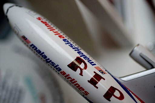 -FILE- This Tuesday Sept. 9, 2014, file image shows a Malaysia Airlines miniature plane with a text reading &quot;RIP MH17&quot;, displayed at a memorial site for the victims of the MH17 air disaster at Schiphol Airport in Amsterdam, Netherlands. United by grief across oceans and continents, families who lost loved ones when Malaysia Airlines Flight 17 was shot down in 2014 hope that a trial starting next week will finally deliver them something that has remained elusive ever since: The truth. (AP Photo/Peter Dejong, File)