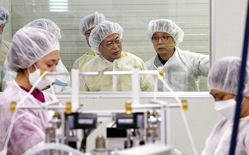 South Korean President Moon Jae-in, rear center, looks around the production line of mask at Wooil C&amp;Tech in Pyeongtaek, South Korea, Friday, March 6, 2020. North Korea said Friday it has released about 220 foreigners from a quarantine imposed as part of its vigilant prevention efforts to avoid an outbreak of the coronavirus that has spread around the world. (Lee Jin-wook/Yonhap via AP)