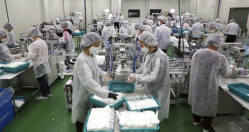 Company employees work in the production line of mask at Wooil C&amp;Tech in Pyeongtaek, South Korea, Friday, March 6, 2020. North Korea said Friday it has released about 220 foreigners from a quarantine imposed as part of its vigilant prevention efforts to avoid an outbreak of the coronavirus that has spread around the world. (Lee Jin-wook/Yonhap via AP)