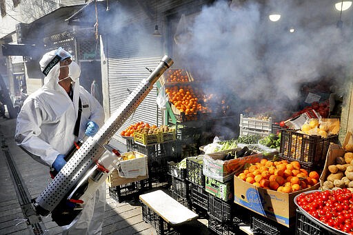 A firefighter disinfects a traditional shopping center to help prevent the spread of the new coronavirus in northern Tehran, Iran, Friday, March, 6, 2020. A Health Ministry spokesman warned authorities could use unspecified &#147;force&#148; to halt travel between major cities.  (AP Photo/Ebrahim Noroozi)