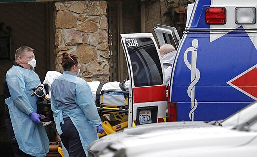 Ambulance workers move a man on a stretcher from the Life Care Center in Kirkland, Wash. into an ambulance, Friday, March 6, 2020. The facility is the epicenter of the outbreak of the the COVID-19 coronavirus in Washington state. (AP Photo/Ted S. Warren)