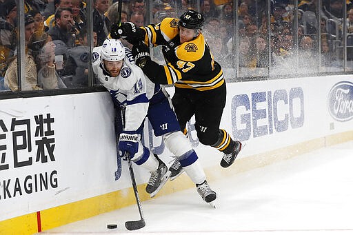 Boston Bruins' Torey Krug, right, checks Tampa Bay Lightning's Barclay Goodrow into the boards during the third period of an NHL hockey game Saturday, March 7, 2020, in Boston. (AP Photo/Winslow Townson)